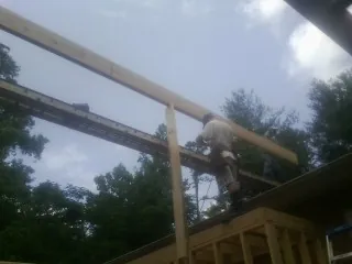 Carpenter setting a ridge beam over a new addition frame — Ice Dam Removal by Roofing Brothers in Cowen