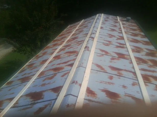 Rusted metal roof panels with new wood purlins before replacement — Storm Damage Roof Repair in Cowen by Roofing Brothers