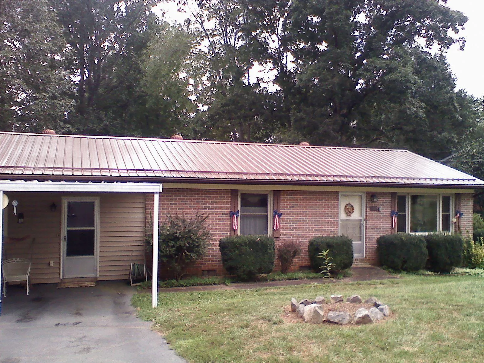 Bronze metal roof and carport on a brick ranch home — Roof Repair work by our crew in Cowen